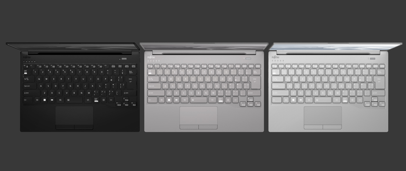 Three Fujitsu LIFEBOOK UH-X laptops shown top-down, lids partly open, comparing the keyboards across three available finishes: black on the left, silver in the middle, brighter silver on the right.