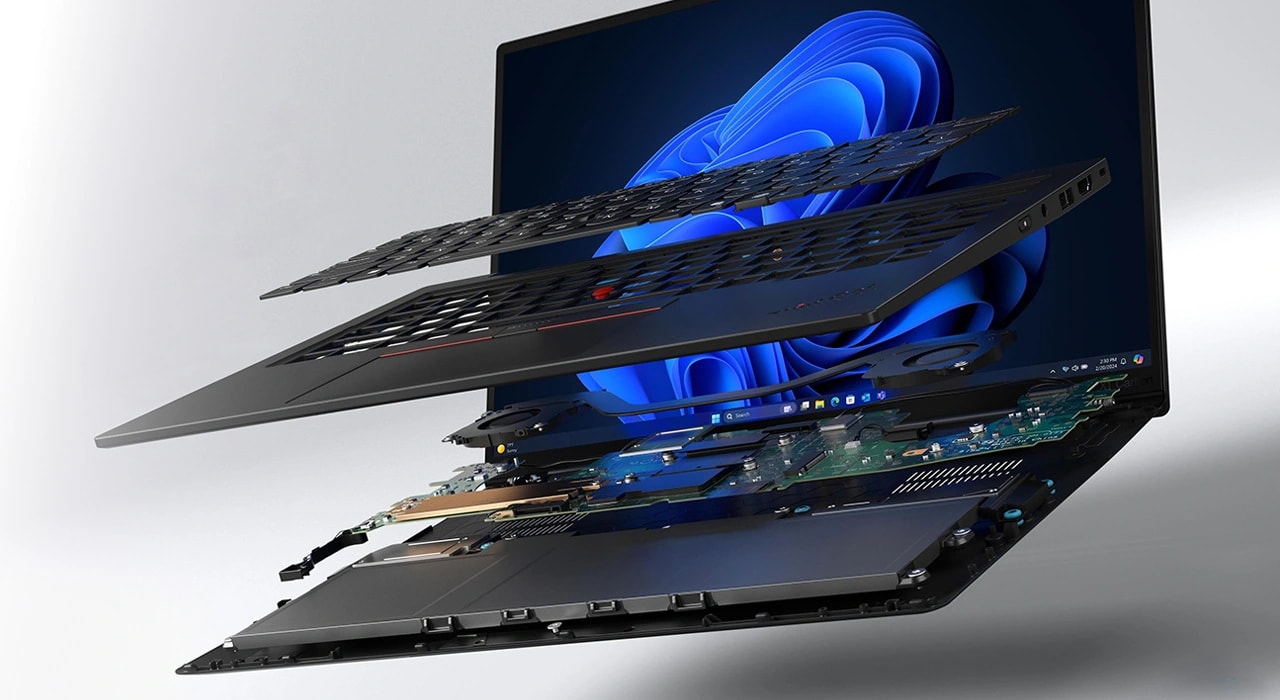 An exploded view of the X1 Carbon Aura — keyboard layer, motherboard layer, and bottom shell pulled apart to show the internal layout.