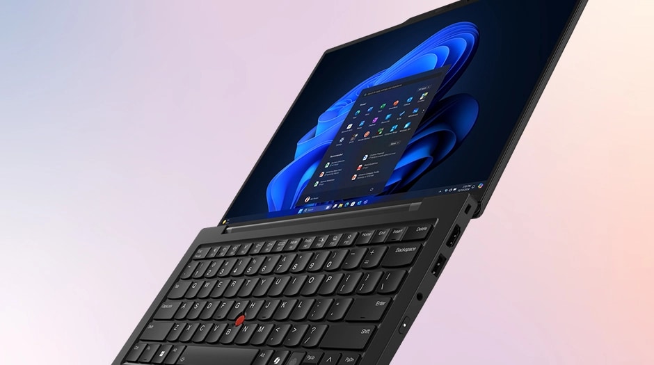 Low-angle view of the X1 Carbon Aura, lid open at roughly 90 degrees, showing the side profile and the right-side ports.